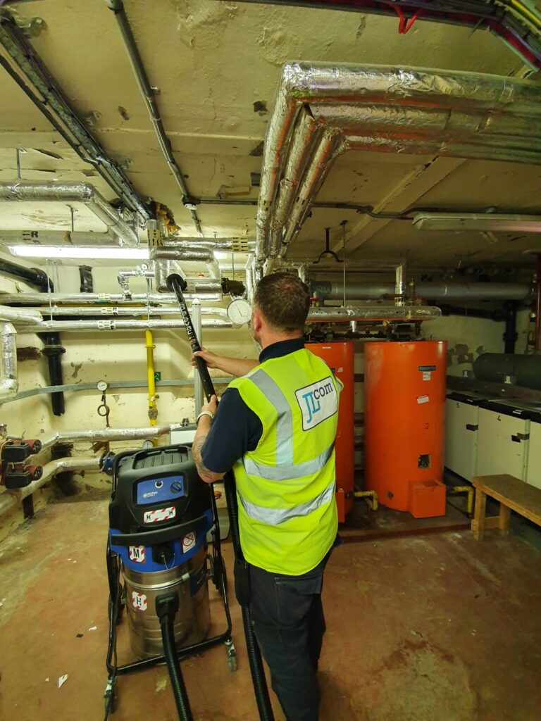 Operator using an ATEX-rated vacuum unit in a manufacturing facility